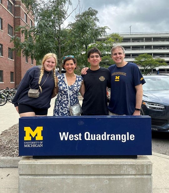 people in front of university of michigan sign