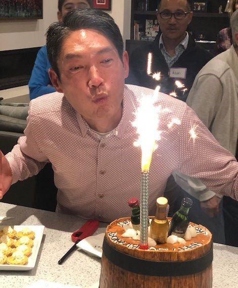 Kenji Celebrating with his many Scotch bottles
